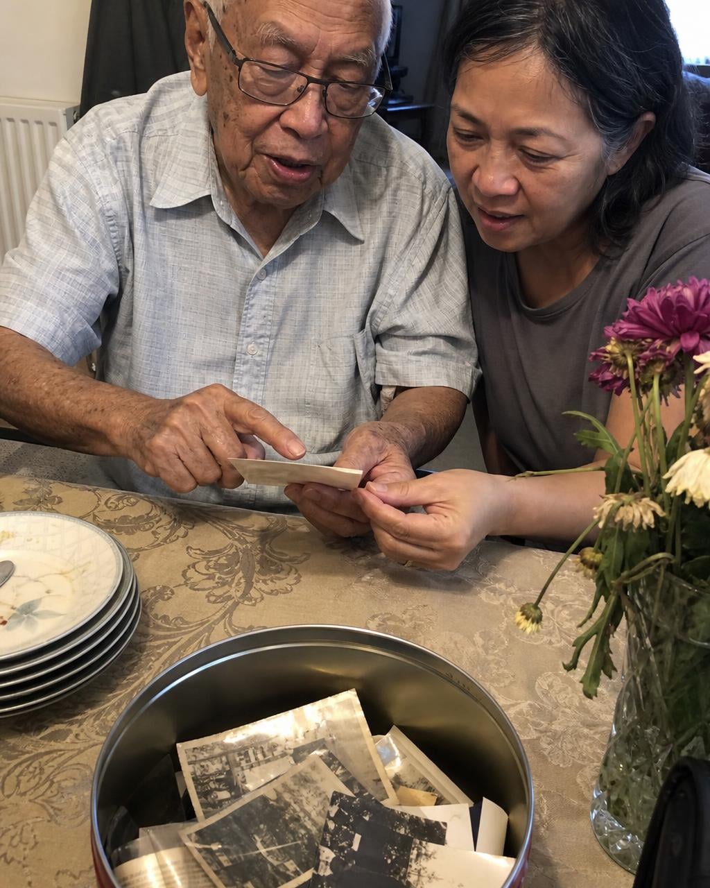 Two family members holding an old photograph between them